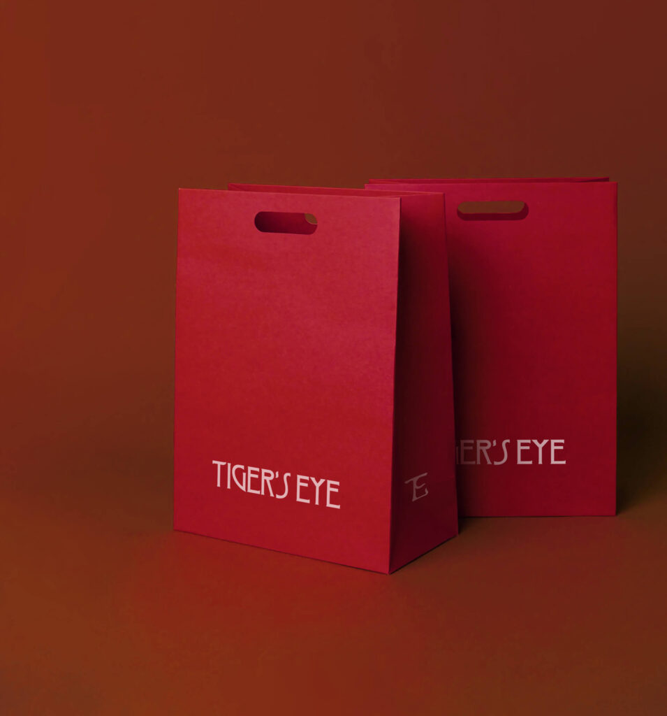 Tiger’s Eye red paper shopper, with the agency’s logo in white on it.